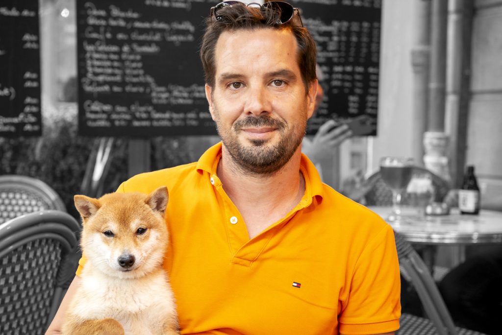 Chiot mame shiba roux dans les bras de son maître, en terrasse de café